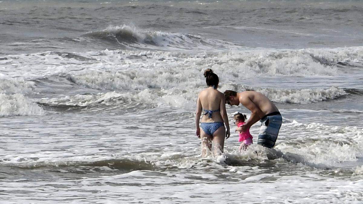 Josh and Cara Denton play with their daughter Addie in the surf on Tuesday morning on Hilton Head Island. The family, visiting from Bristol, Tennessee, made arrangements in June for their condo vacation and decided to make the trip. Whle the beach was practically theirs, they were disappointed that there were very few businesses open. “I completely understand why they did (close),” Josh said. “We’re probably going to pack up and leave on Wednesday..”