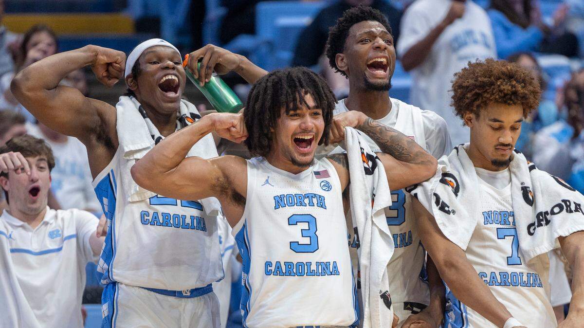 North Carolina players Ven-Allen Lubin (22), Elliot Cadeau (3), Jalen Washington (13) and Seth Trimble (7) react after a basket by Ty Claude to give the Tar Heels a commanding 98-51 lead over American University in the closing minutes of play on Friday, November 15, 2024 at the Smith Center in Chapel Hill, N.C.