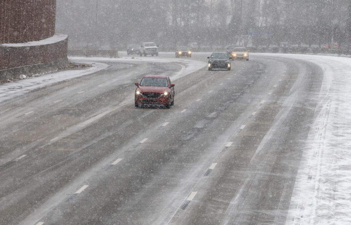 Snow falls as traffic moves along Interstate 85 on Saturday, Jan. 31, 2026, in Durham, N.C.