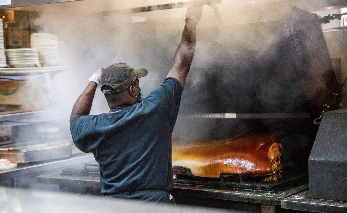 Pit Master Sherman Perry smokes a pig during a mock service to help bring staff up to speed on new safety measures to prevent against the spread of coronavirus at The Pit in Raleigh Tuesday, May 26, 2020.The Pit owner Greg Hatem says he expects to open for dine-in on Wednesday afternoon, May 27, 2020.