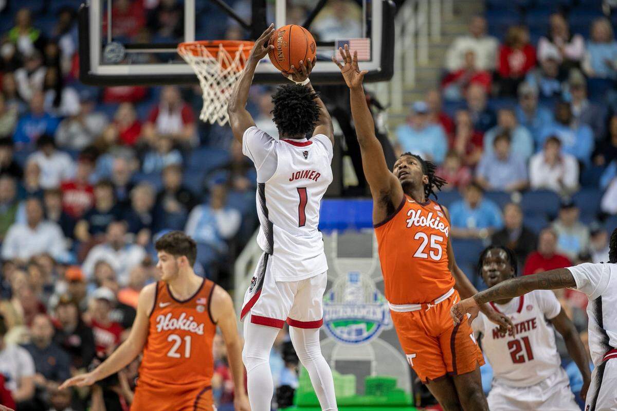 N.C. State’s Jarkel Joiner (1) launches a three point shot over Virginia Tech’s Justyn Mutts (25) in the first half against Virginia Tech in the second round of the ACC Tournament on Wednesday, March 8, 2023 at the Greensboro Coliseum in Greensboro, N.C.
