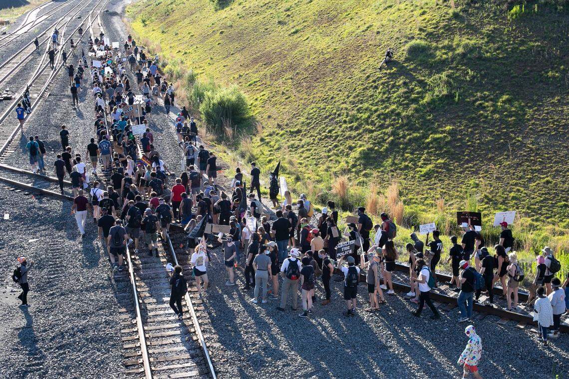 Protesters march along the railroad tracks beneath the Boylan Avenue Bridge to Central Prison for a rally on police and orison reform on Saturday, June 13, 2020 in Raleigh, N.C.