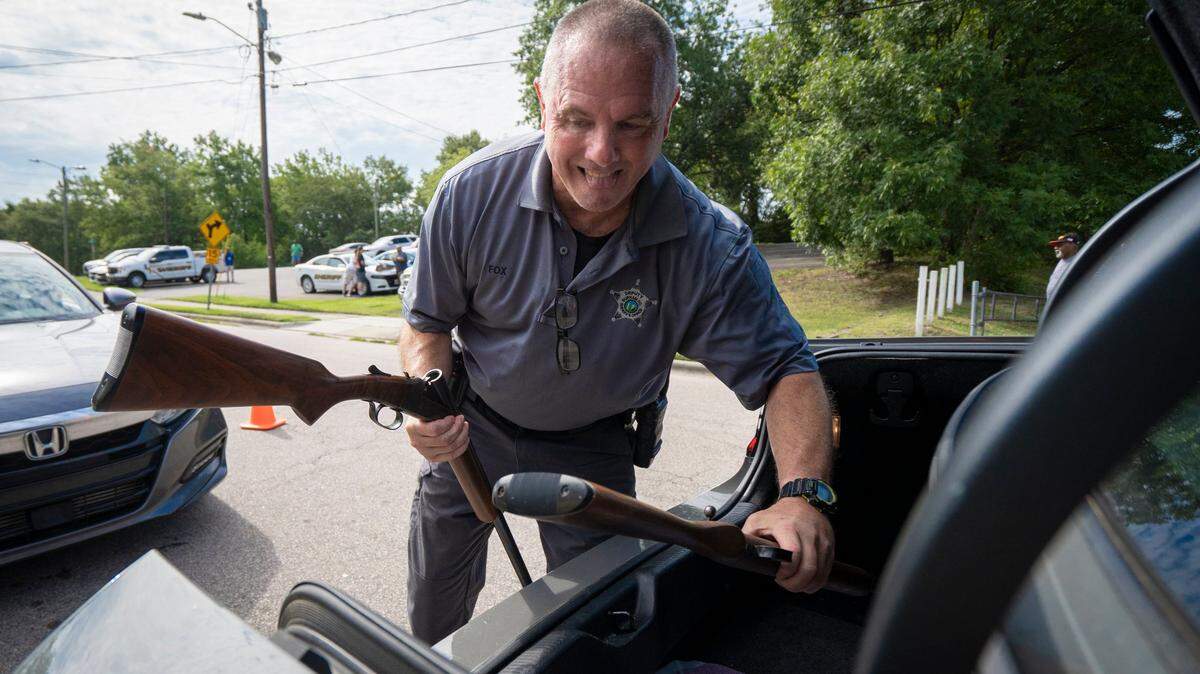 Deputy Fox retrieves rifles from a trunk at the Gun Buyback hosted by the Durham County Sheriffs Office in Durham, N.C. on Saturday, Aug. 6, 2022. After the Durham buyback drew hundreds of Triangle residents, the city of Raleigh will host its own later this month.