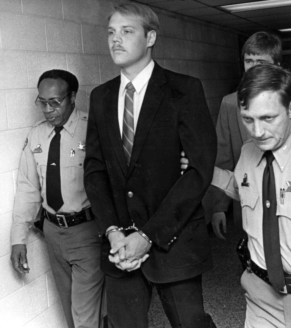Timothy Bailey Hennis, center is lead to his first court appearance. May 20, 1985 (Mandatory Credit: The Fayetteville Observer)