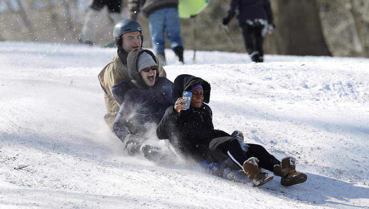 From left, Brandon Bielat, Holly Buickerood and Darcy Ficek head down a hill at Dix Park in Raleigh, N.C., Sunday, Feb. 1, 2026.