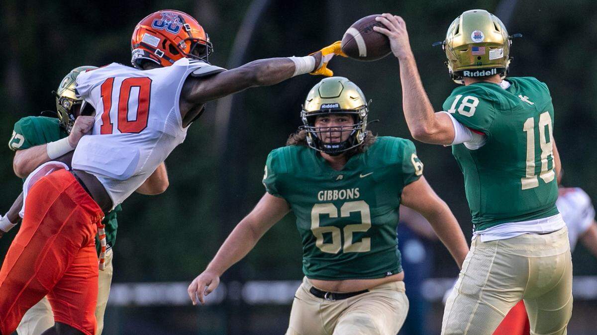 Cardinal Gibbons quarterback Connor Clark (18) is pressured by Julius Chambers’ James Pearce (10) in the first quarter on Friday, August 29, 2021 in Raleigh, N.C.