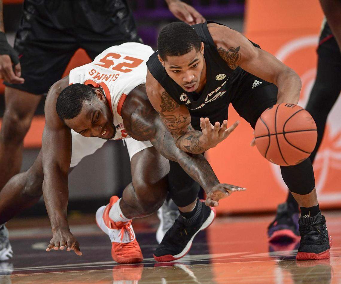 Clemson senior forward Aamir Simms(25) and NC State guard Shakeel Moore(2) reach for a loose ball during the first half of their game on Jan 5, 2021.