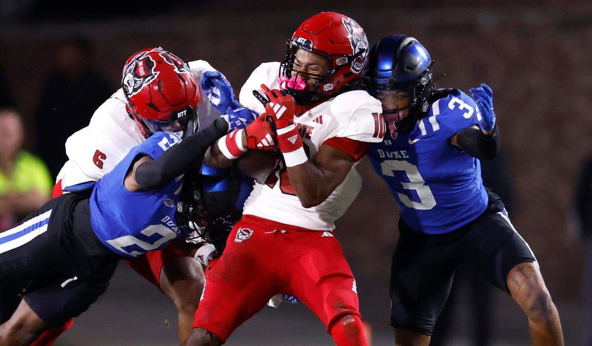 N.C. State wide receiver KC Concepcion (10) is hit by Duke’s Jaylen Stinson (2) and Brandon Johnson (3) during the first half of N.C. State’s game against Duke at Wallace Wade Stadium in Durham, N.C., Saturday, Oct. 14, 2023.