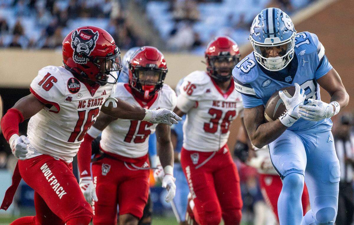 North Carolina receiver J.J. Jones (13) scores a touchdown on a 17-yard pass from quarterback Jacolby Criswell in the second quarter ahead of N.C State’s Devon Marshall (16) on Saturday, November 30, 2024 at Kenan Stadium in Chapel Hill, N.C.