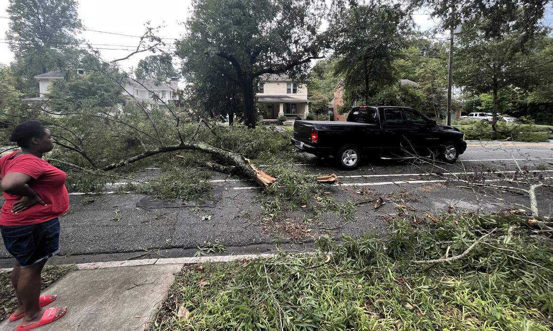Residents clear tree branches from West Club Blvd at Maryland Ave. in Durham, N.C., on Tuesday, August 15, 2023.