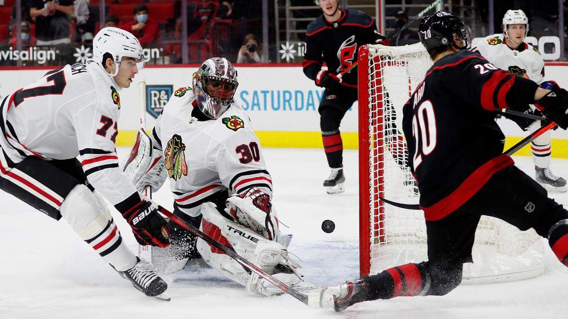 Carolina Hurricanes forward Sebastian Aho (20) slips the puck past Chicago Blackhawks goaltender Malcolm Subban (30) and the Blackhawks’ Kirby Dach (77) for a goal during the second period Monday, May 3, 2021.