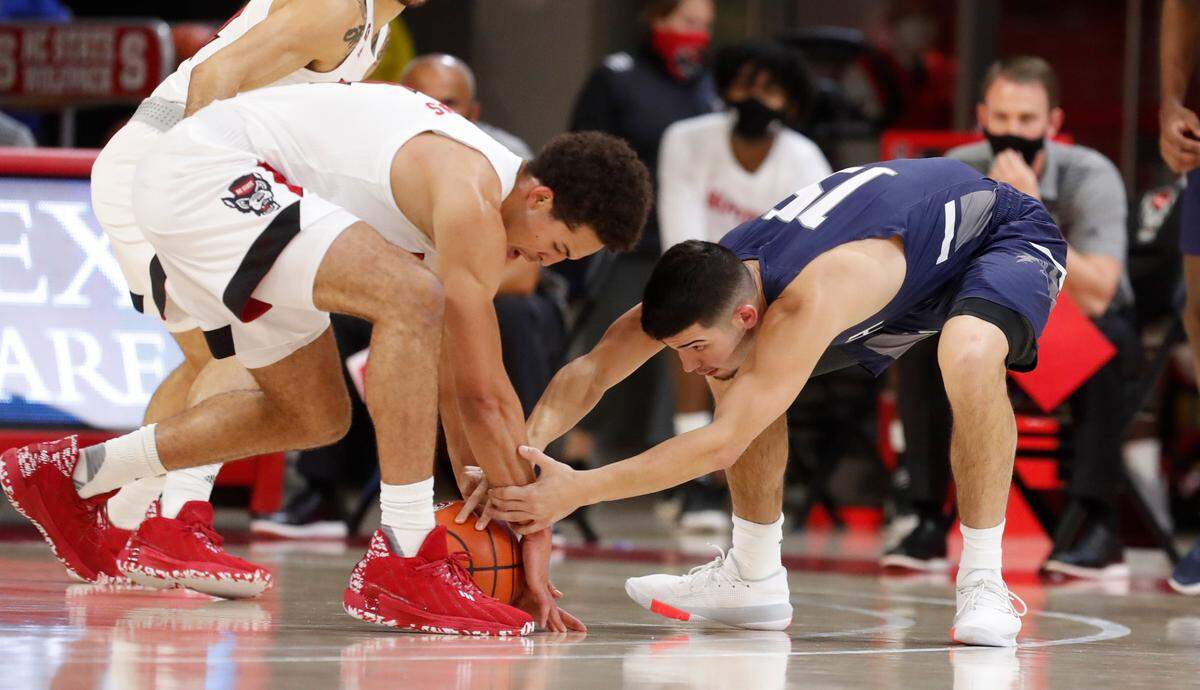 N.C. State’s Jericole Hellems (4) takes the loose ball from North Florida’s Jose Placer (15) during the first half of N.C. State’s game against North Florida in the Mako Medical Wolfpack Invitational at Reynolds Coliseum in Raleigh, N.C., Friday, Nov. 27, 2020.