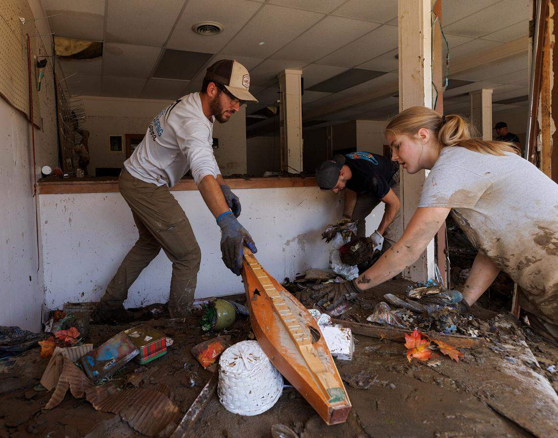 Andrew Zook, left, helps to clear instruments and other items from the mud inside Majestic Music in downtown Spruce Pine, N.C. on Thursday, Oct. 3, 2024, days after Hurricane Helene brought heavy flooding to the area.