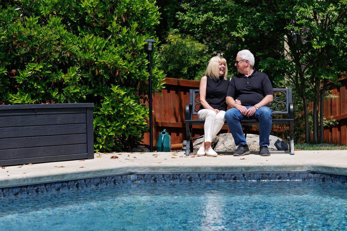 Terri and Chris Darden, who recently relocated to Raleigh, share a laugh while sitting near their backyard pool on April 24, 2025.