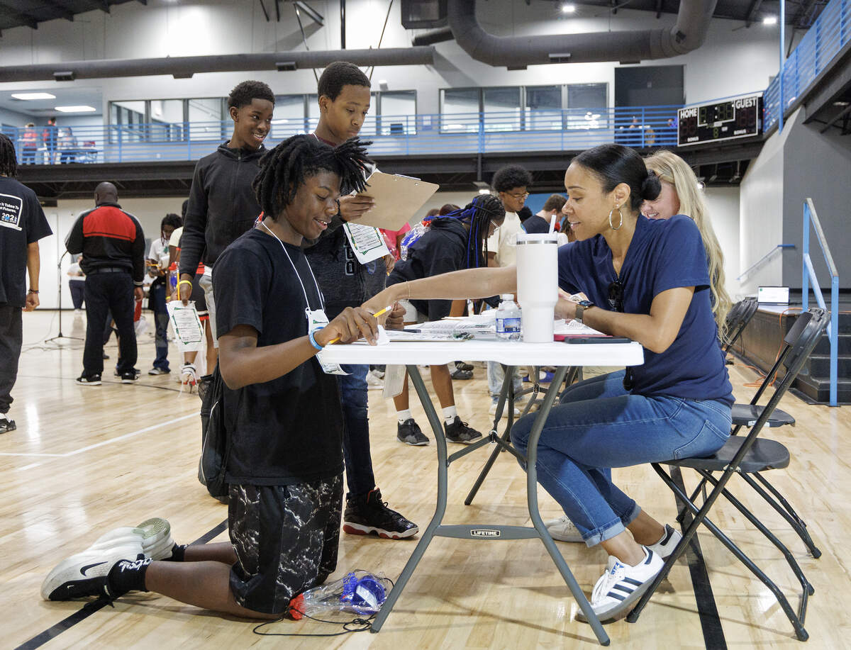Mason, left, works with Alexis Turner, a volunteer from Morgan Stanley, to decide how much he should spend on clothing each month.