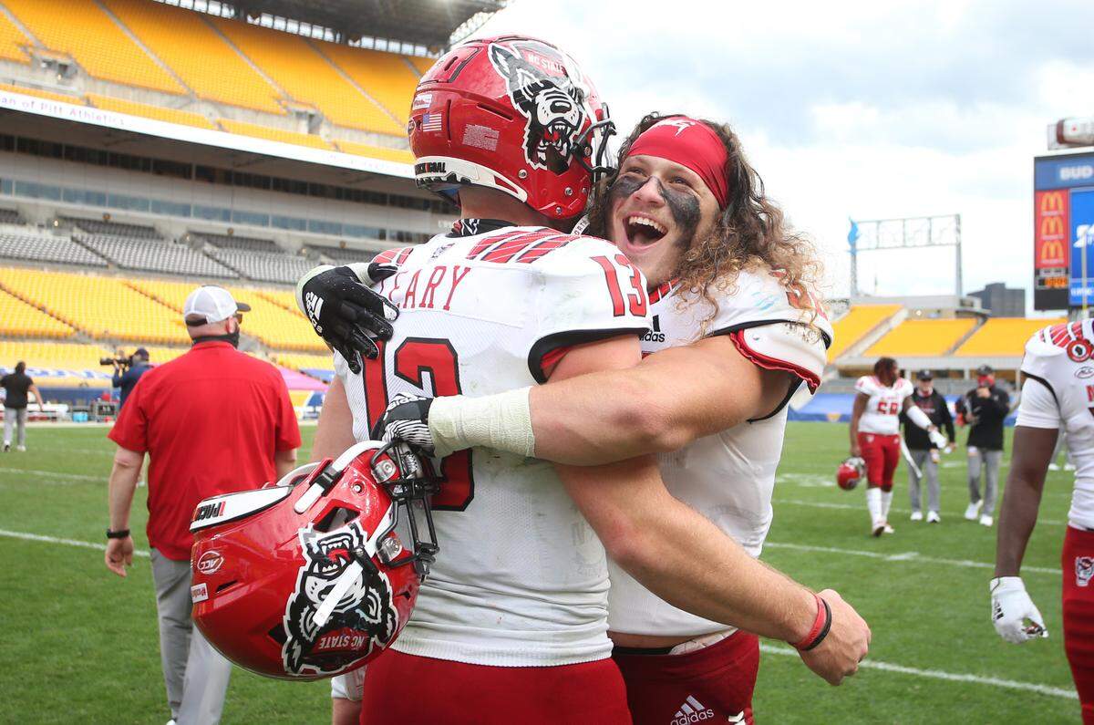 N.C. State’s Devin Leary (13) and linebacker Drake Thomas (32) celebrate after defeating the Pittsburgh Panthers at Heinz Field in Pittsburgh, PA, Saturday, Oct. 3, 2020.