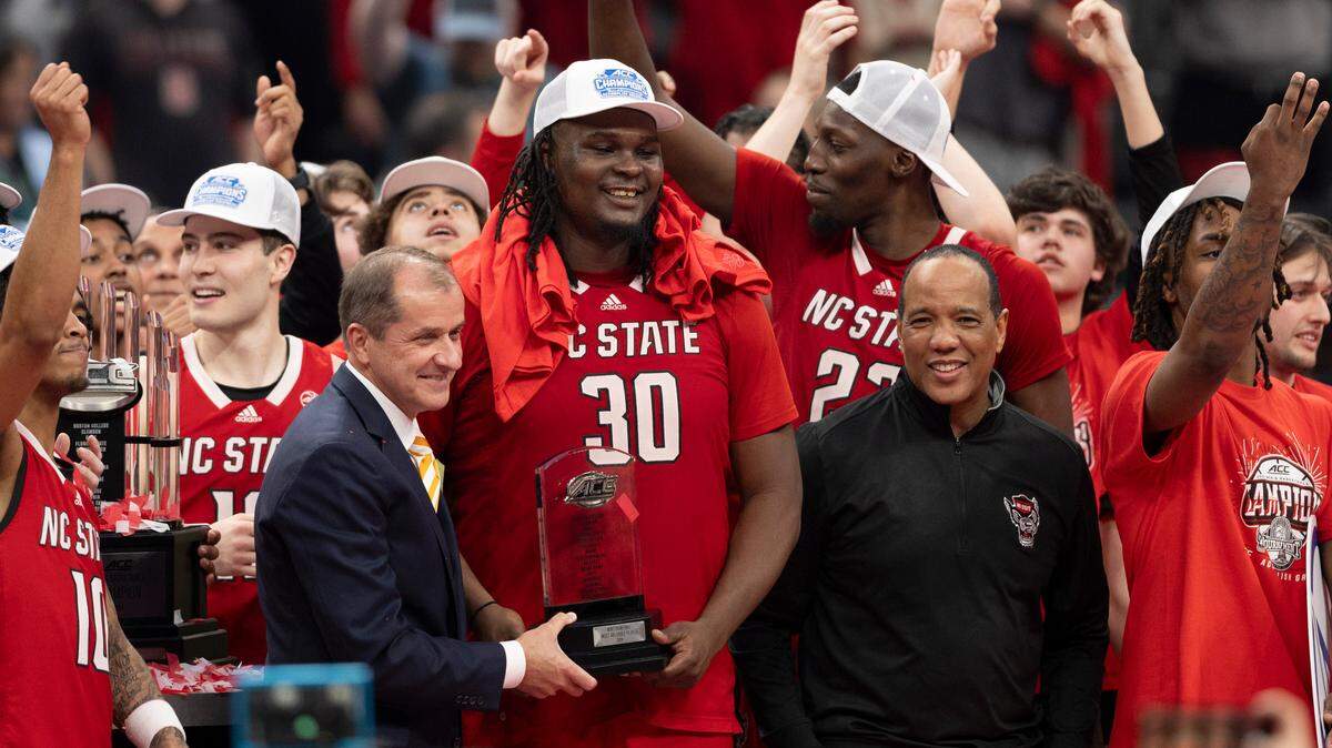 ACC Commissioner Jim Phillips presents the tournament MVP trophy to N.C. State’s D.J. Burns Jr. (30) following the Wolfpack’s ACC Tournament victory over North Carolina at Capitol One Arena on Saturday, March 16, 2024 in Washington, D.C.