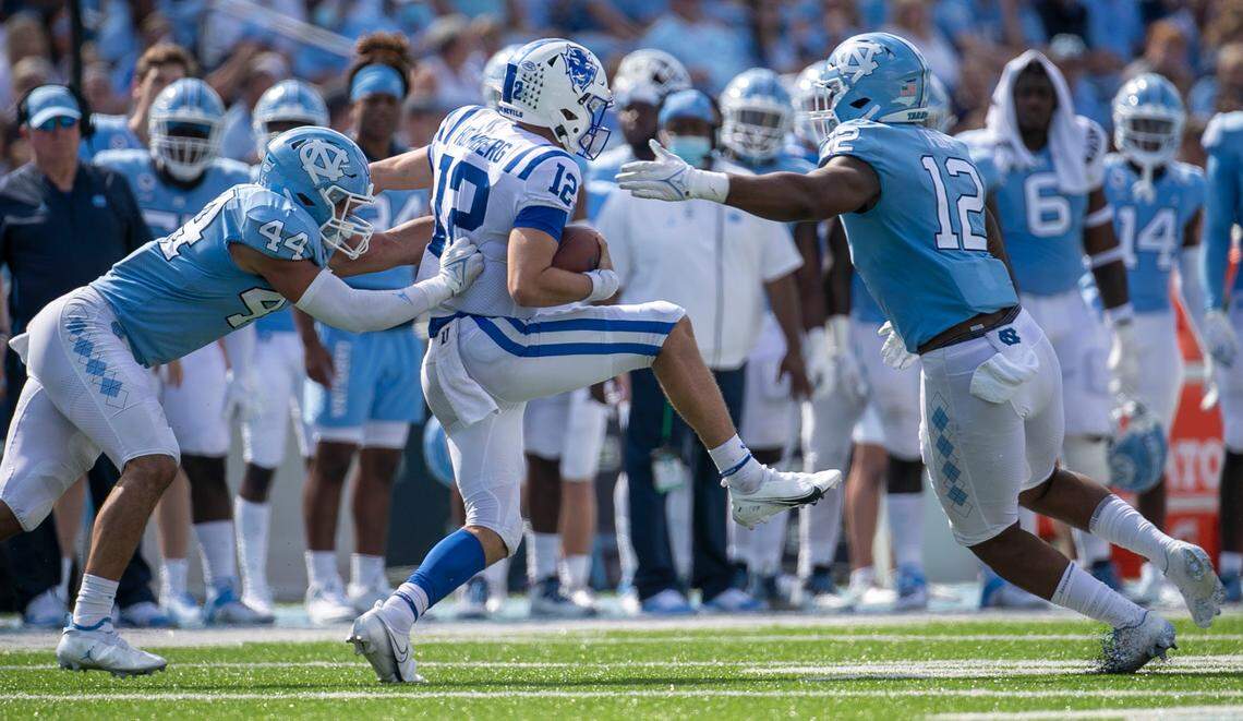 Duke quarterback Gunnar Holmberg (12) is stopped after a four yard gain in the fourth quarter by North Carolina’s Jeremiah Gemmel (4) and Tomon Fox (12) on Saturday, October 2, 2021 at Kenan Stadium in Chapel Hill, N.C.