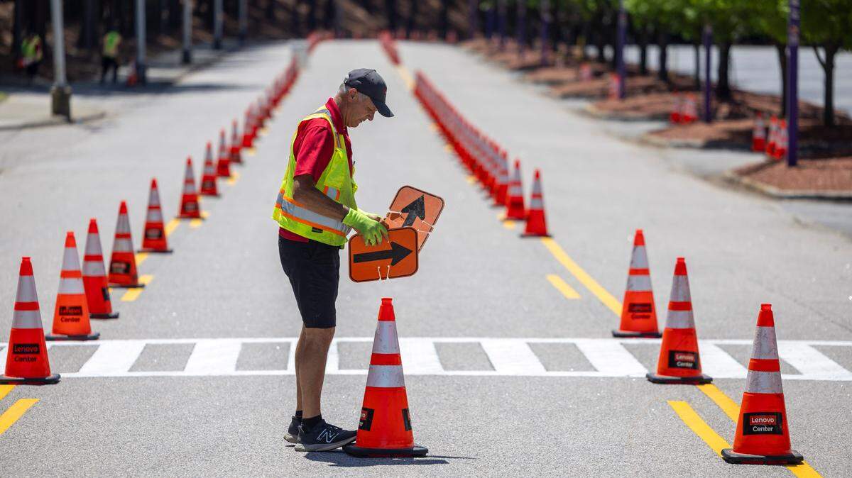Tim Layn places directional signs along E. Stephen Stroud Way outside Lenovo Arena as staff prepares for the Linkin Park concert on Tuesday, May 6, 2025 at Lenovo Center in Raleigh, N.C. Lenovo Center employees place more than 2000 cones directing traffic to parking spots and exits for each event at the arena.