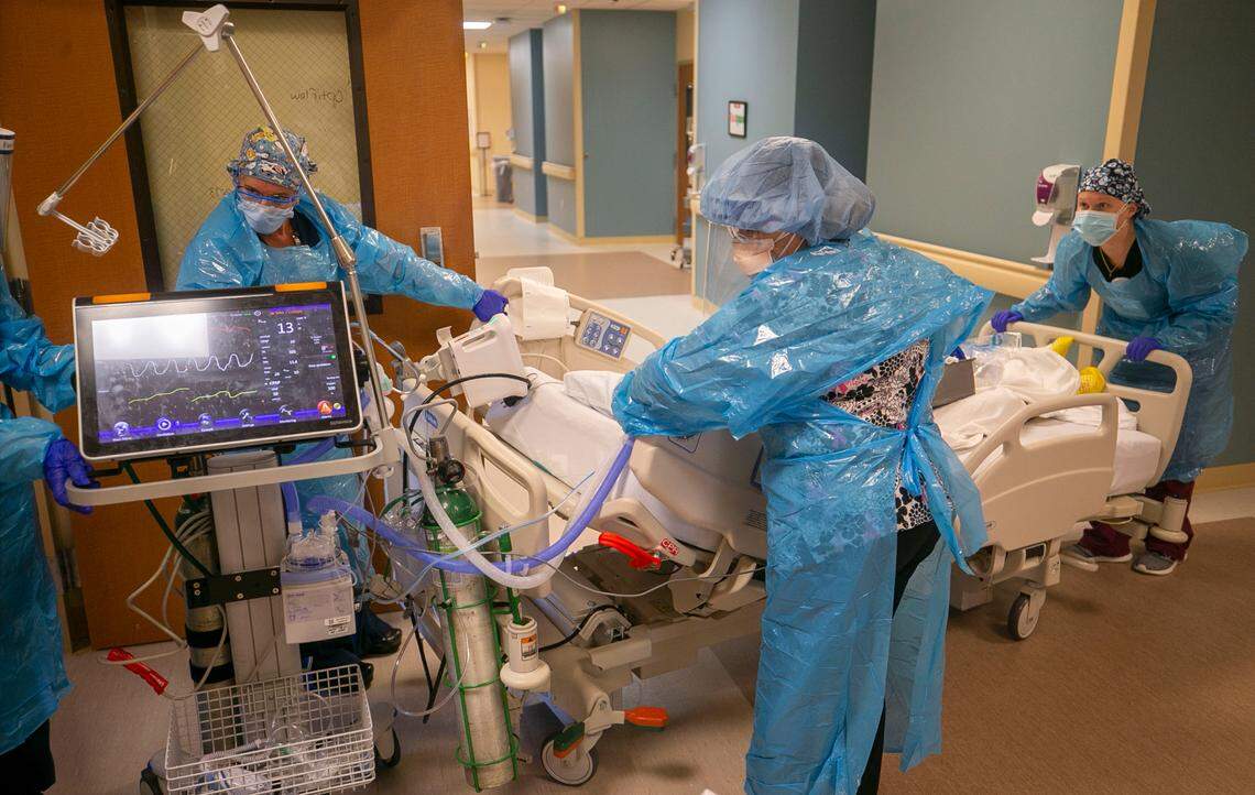 A team of nurses and respiratory therapists move a patient into the intensive care unit at Johnston UNC Health Care on Thursday, August 19. 2021 in Clayton, N.C. The 10-bed intensive care unit is completely full of COVID-19 patients.