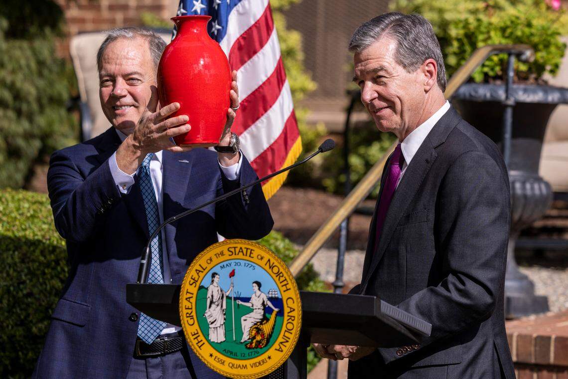 Gov. Roy Cooper, right, presents Wolfspeed CEO Gregg Lowe with a piece of pottery as a gift during an economic development announcement ceremony at the Executive Mansion Friday, Sept. 9, 2022. Wolfspeed, a Durham silicon chip manufacturer, will build a new factory in Chatham County promising 1,800 new jobs.