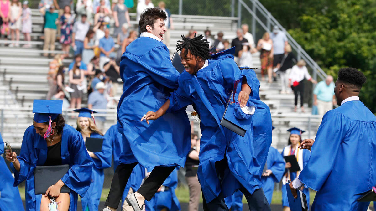 Cody Britt, left, and Chris Moore celebrate after Wake Forest High School’s Class of 2021 graduation ceremonies at the Heritage High School football stadium in Wake Forest, N.C., Wednesday, June 9, 2021.