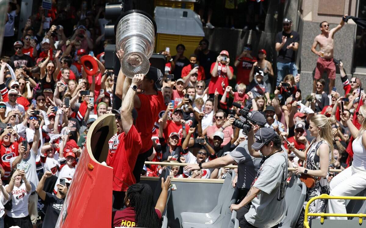The Canes, including Carolina's Jaccob Slavin  and Sebastian Aho raise the cup while riding down Fayetteville St. during a parade and rally for the Carolina Hurricanes in downtown Raleigh Saturday, June 20, 2026.