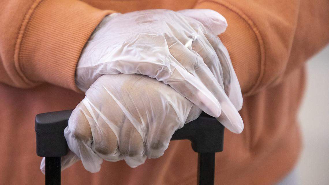 Sabyra Stokes, a freshman at Winton-Salem State University, wears gloves as she travels through Raleigh-Durham International Airport for a spring break trip in Atlanta, Ga., despite the restriction of some domestic and international travel in an effort to contain the spread of COVID-19, on Thursday, Mar. 12, 2020, in Morrisville, N.C.