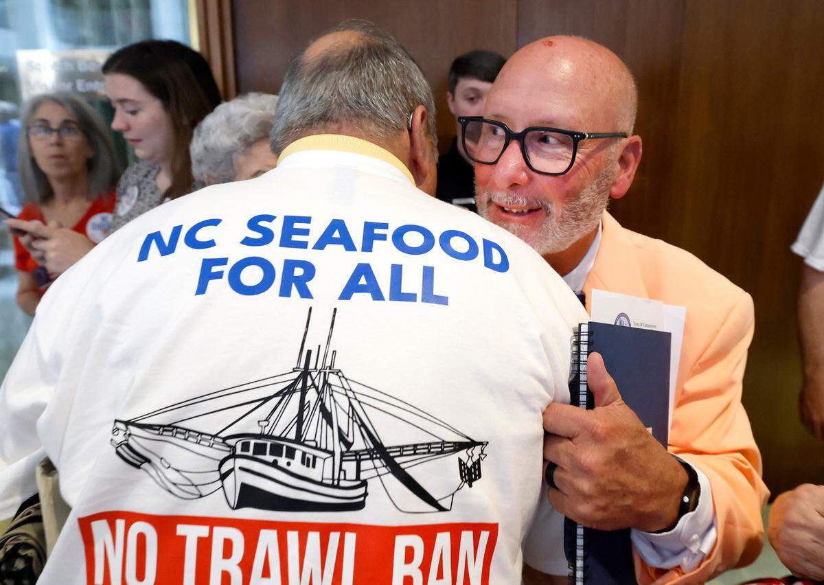N.C. State Sen. Bobby Hanig gets a hug during a protest of House Bill 442 at the Legislature Building Tuesday, June 24, 2025. House Bill 442 bans commercial shrimp trawling in inshore waters, including sounds.