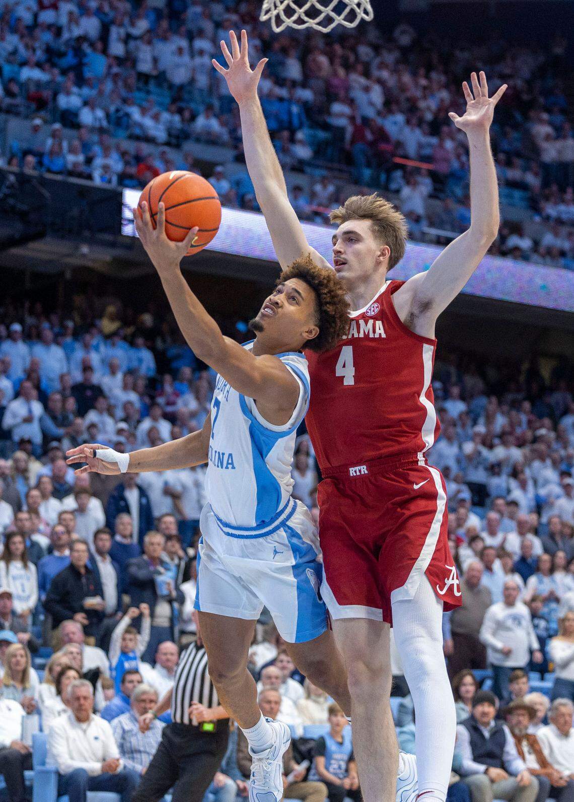 North Carolina guard Seth Trimble (7) drives to the basket against Alabama forward Grant Nelson (4) in the first half against Alabama on Wednesday, December 4, 2024 at the Smith Center in Chapel Hill, N.C.