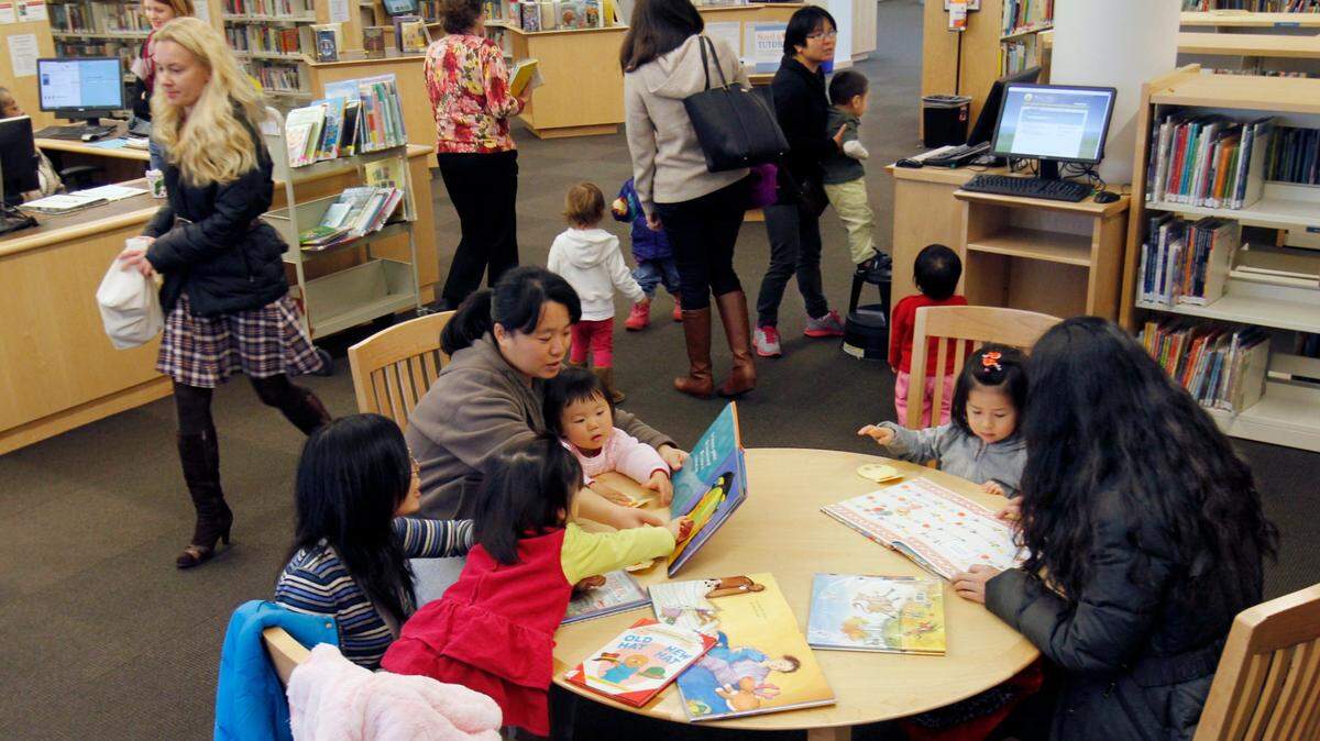 Families read books in the Chapel Hill Library in 2014. The Diverse Books for a Diverse Community seeks to raise money to acquire books written by Black, Latino, Asian American and LGBTQ authors, books written in other languages and stories that feature children with disabilities.