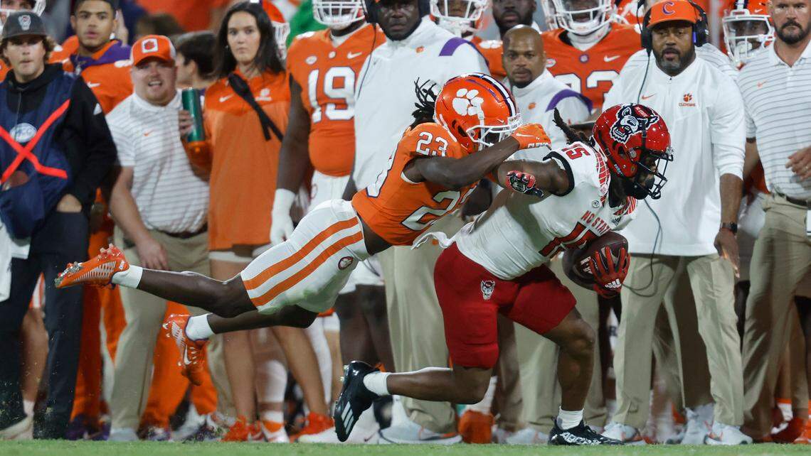 N.C. State wide receiver Keyon Lesane (15) tries to escape from Clemson cornerback Toriano Pride (23) during the second half of Clemson’s 30-20 victory over N.C. State at Memorial Stadium in Clemson, S.C., Saturday, Oct. 1, 2022.