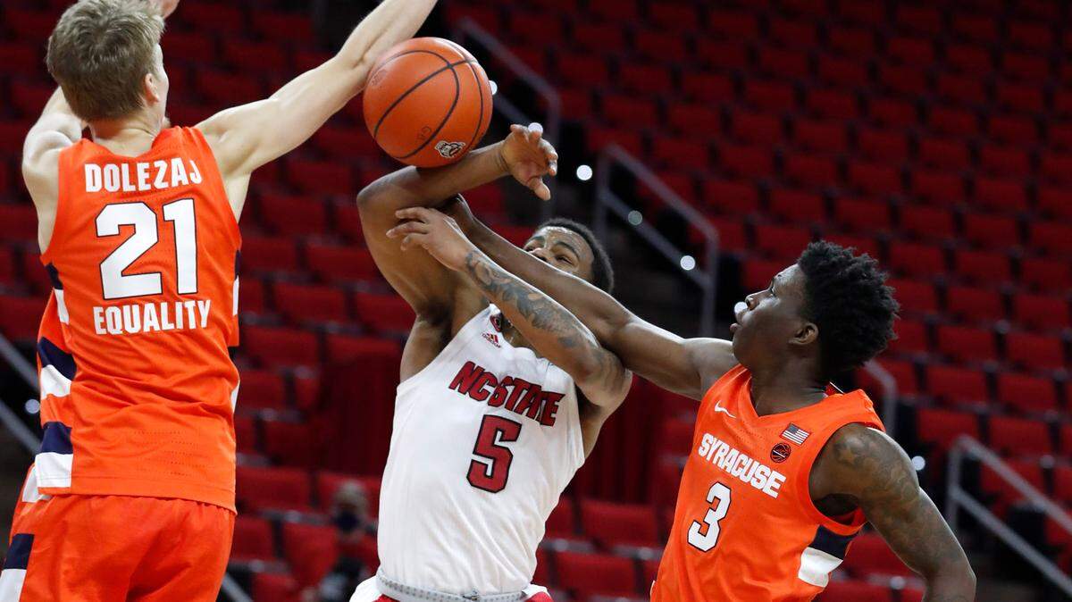 Syracuse’s Kadary Richmond (3) knocks the ball from N.C. State’s Thomas Allen (5) as Syracuse’s Marek Dolezaj (21) also defends during the first half of N.C. State’s game against Syracuse at PNC Arena in Raleigh, N.C., Tuesday, February 9, 2021.