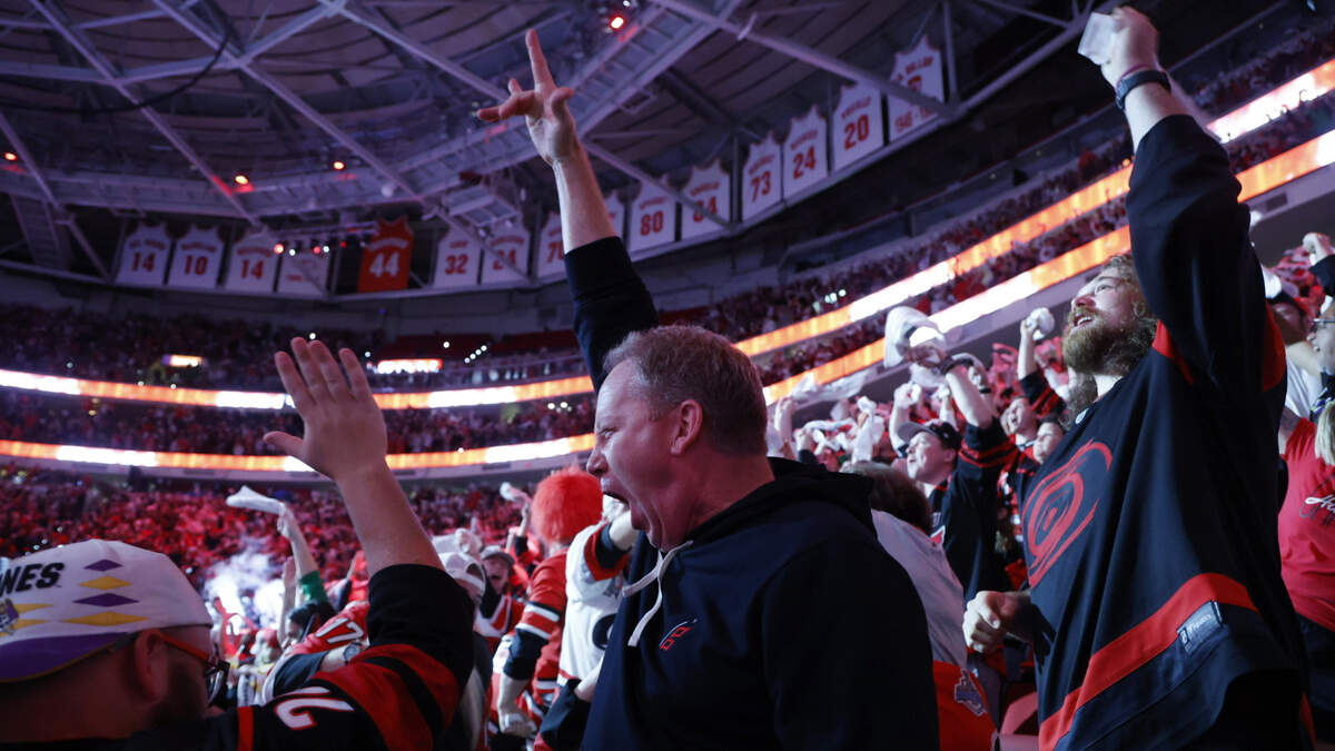 Brendon Penner (center) celebrates with fans at a watch party at the Lenovo Center in Raleigh after the the Canes scored to go up 1-0 over Vegas in the first period of game six of the Stanley Cup Championship.