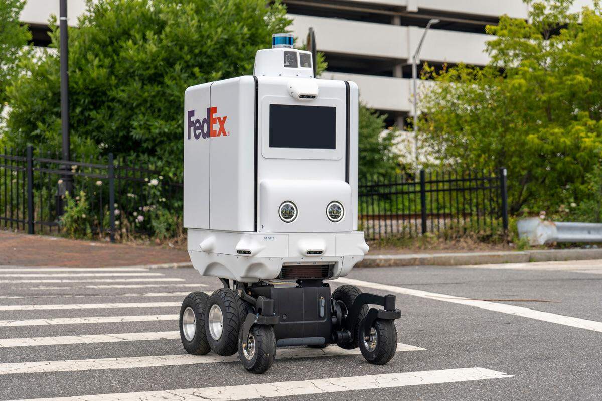 A FedEx delivery robot crosses the street.