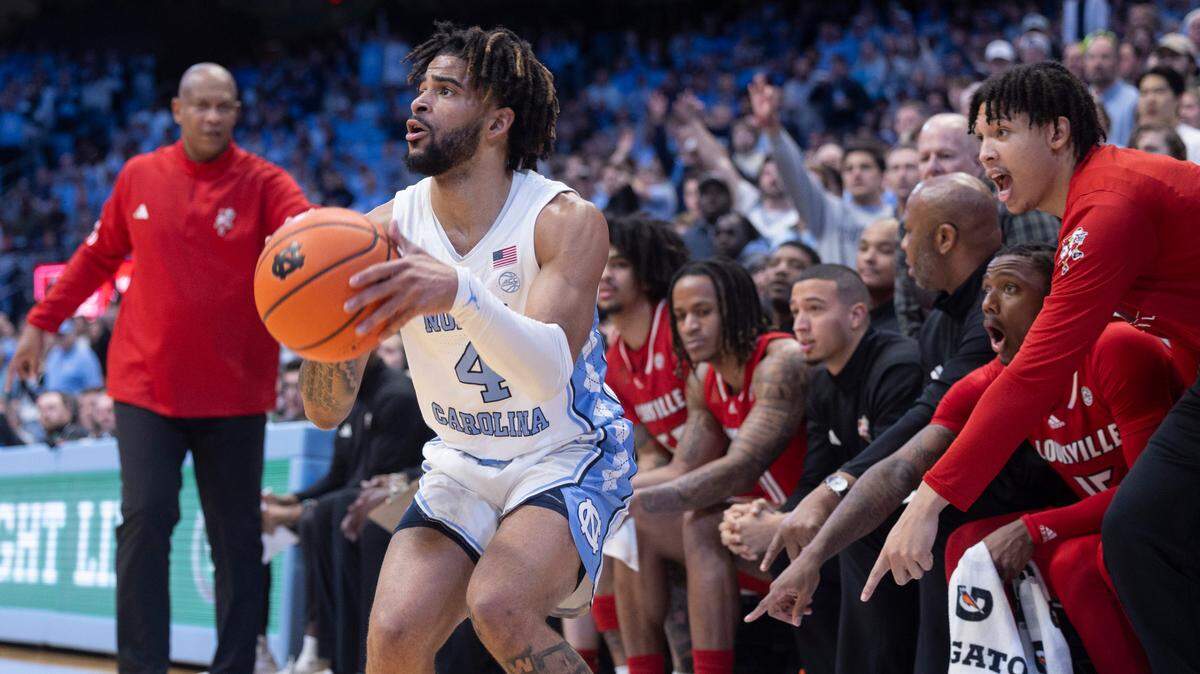 North Carolina’s R.J. Davis (4) lines up a three point shot in front of the Louisville bench in the first half on Wednesday, January 17, 2024 at the Smith Center in. Chapel Hill, N.C.