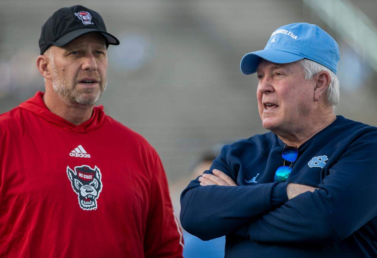 North Carolina coach Mack Brown talks N.C. State coach Dave Doeren prior to their game on Friday, November 25, 2022 at Kenan Stadium in Chapel Hill, N.C.