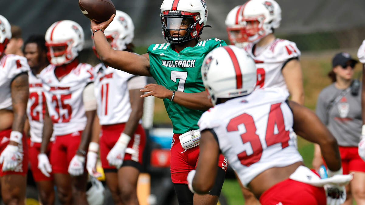 N.C. State quarterback MJ Morris (7) passes to Delbert Mimms III (34) during the Wolfpack’s first fall practice in Raleigh, N.C., Wednesday, August 2, 2023.