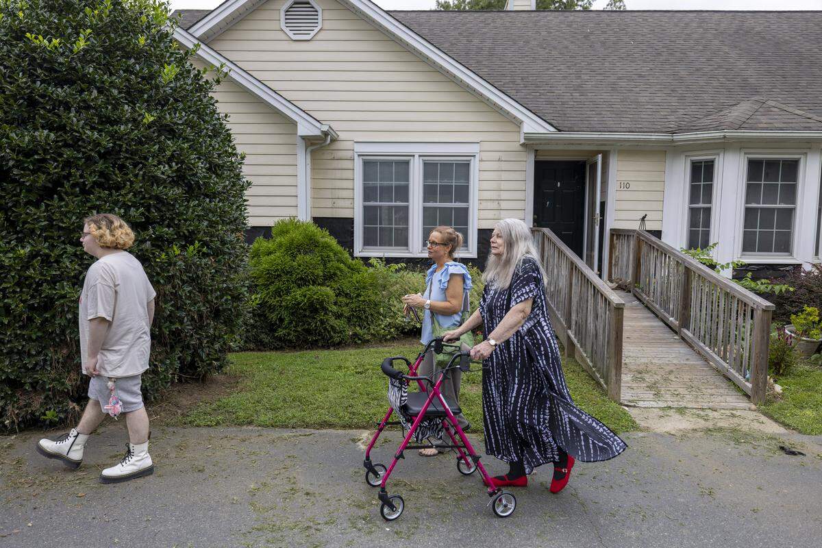 Rey Johnson, Jennifer Johnson and her mother, Steffi Cooper, leave their flood damaged home in the Weatherhill Pointe neighborhood of Carrboro, N.C. after a visit on Tuesday, Aug. 19, weeks after Tropical Storm Chantal. 