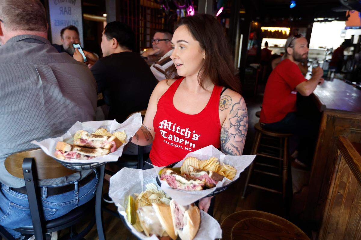 Chelsea Mann serves lunch at Mitch’s Tavern on Hillsborough Street in Raleigh in 2022.