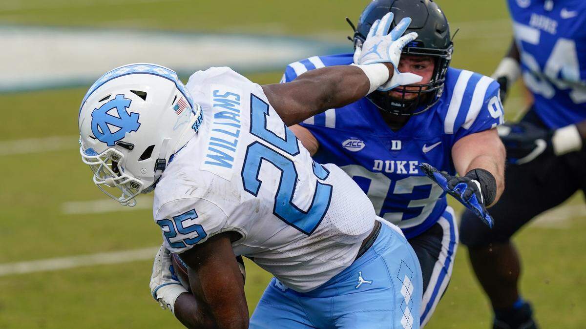 North Carolina Tar Heels running back Javonte Williams (25) pushes off of Duke Blue Devils defensive tackle Ben Frye (93) during the second half at Wallace Wade Stadium.