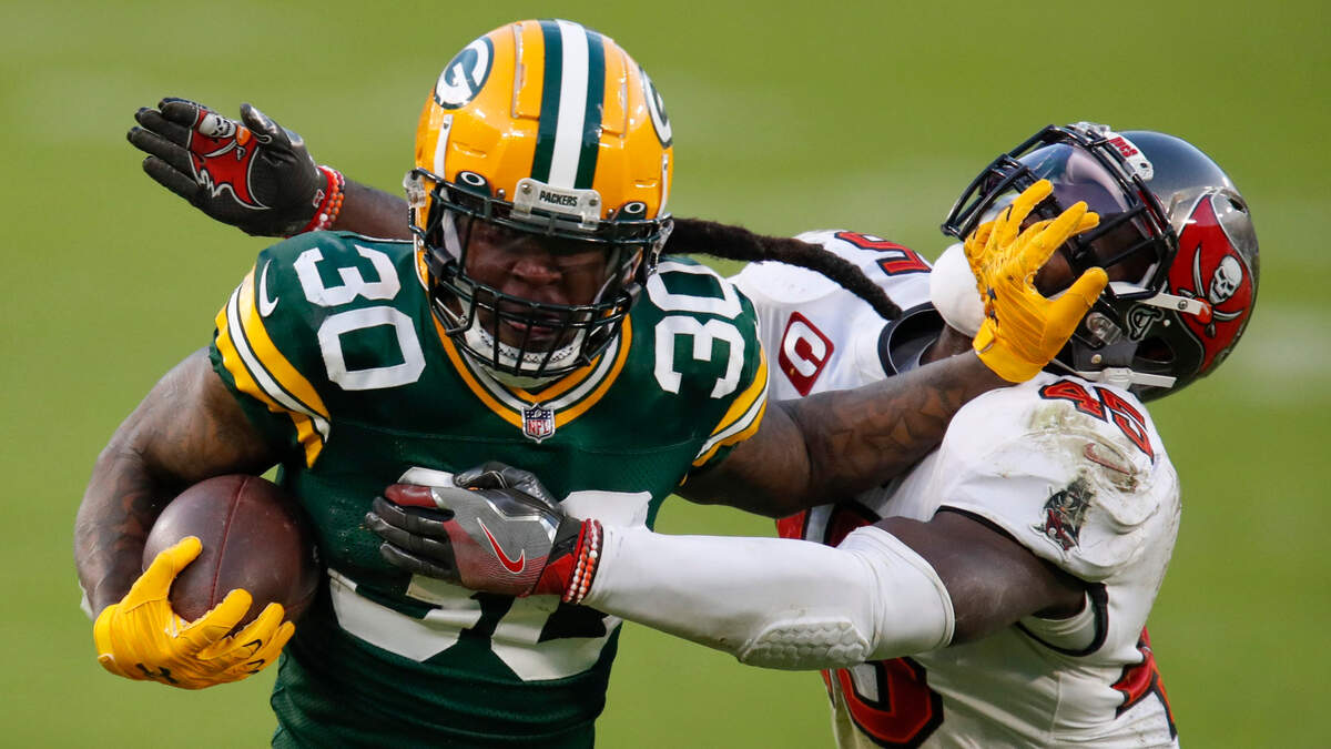 Green Bay Packers’ Jamaal Williams pushes off Tampa Bay Buccaneers’ Devin White during the second half of the NFC championship NFL football game in Green Bay, Wis., Sunday, Jan. 24, 2021.