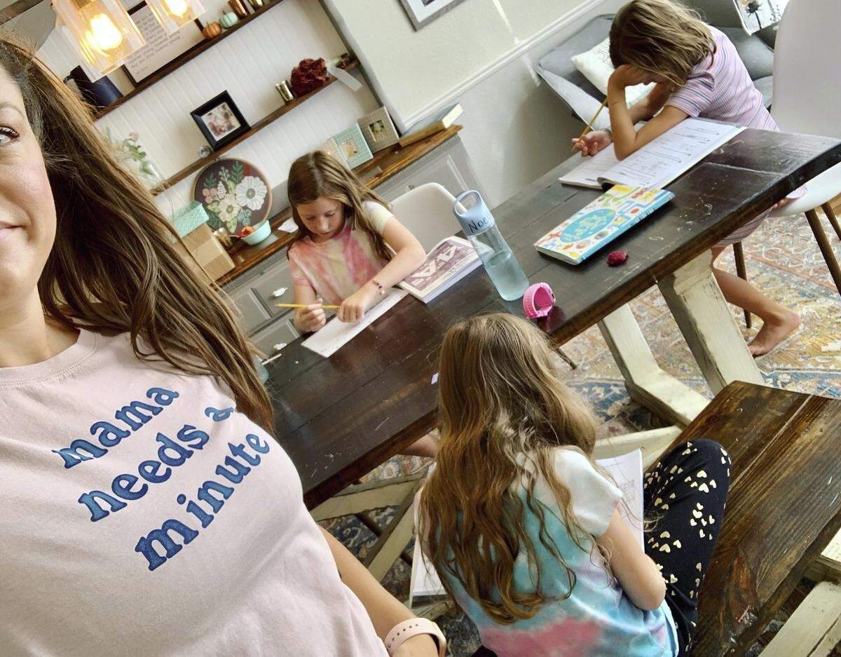 This photo provided by Amber Cessac shows her taking a selfie as her daughters do their homework at their home in Georgetown, Texas on Sept. 9, 2021. The pandemic is still agonizing families, with many women having to make tough decisions about going back to work without affordable child care as an option.