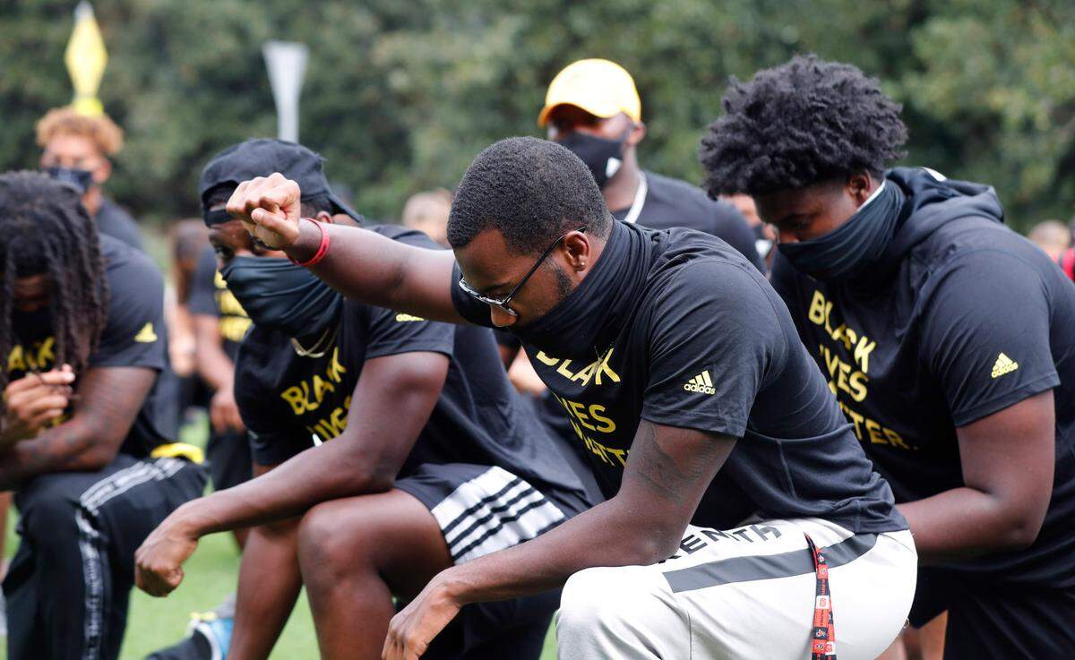 N.C. State athletes, coaches and staff kneel for 8:46, the time police kneeled on George Floyd, during a #PackUnited peaceful protest against racial and social injustice outside Holladay Hall on the campus of N.C. State Saturday, Sept. 12, 2020.