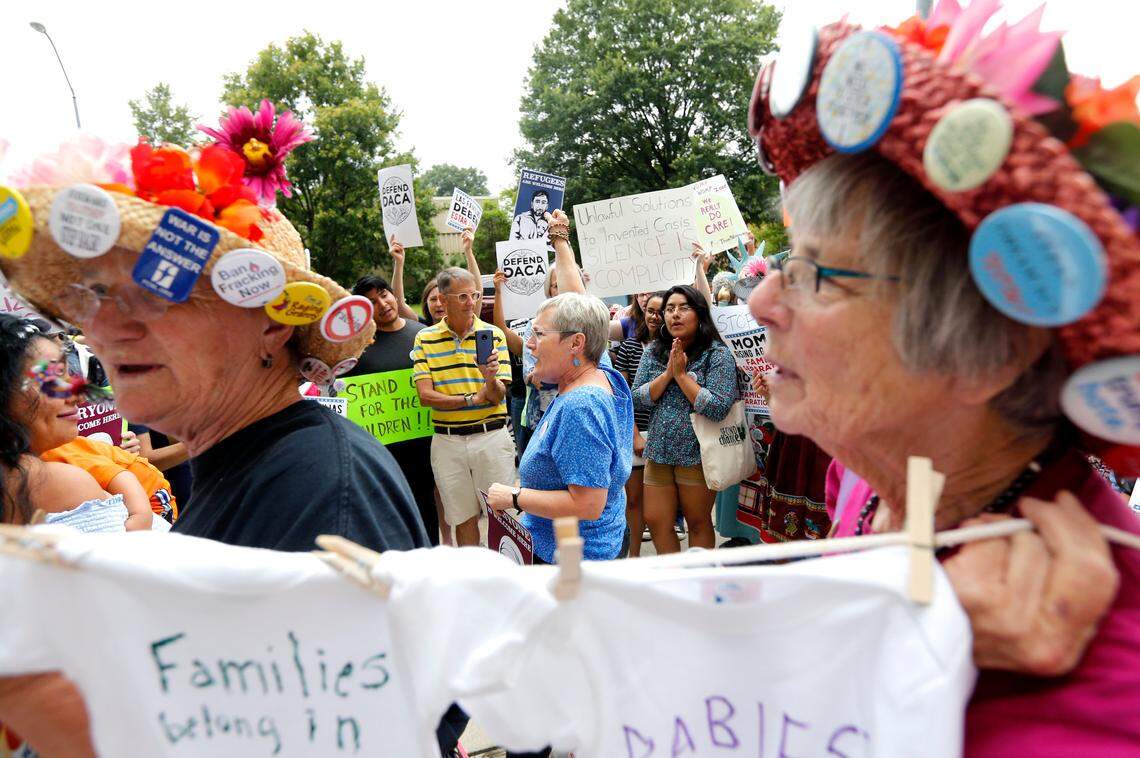 Karen Ziegler, center, of Durham, leads a cheer during a rally to stand against family separation along the southern U.S. border Tuesday, June 26, 2018. The rally, outside the federal building and courthouse in Raleigh, is part of a weekly protest, Tuesdays With Tillis.