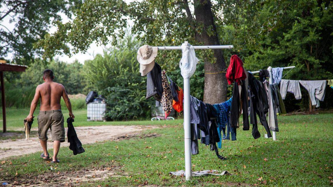 The U.S. Occupational Health and Safety Administration is proposing a federal rule to protect workers from heat illness. Here, a farmworker is shown carrying dried clothes from a clothesline at a Johnston County farmworker camp in August 2020.