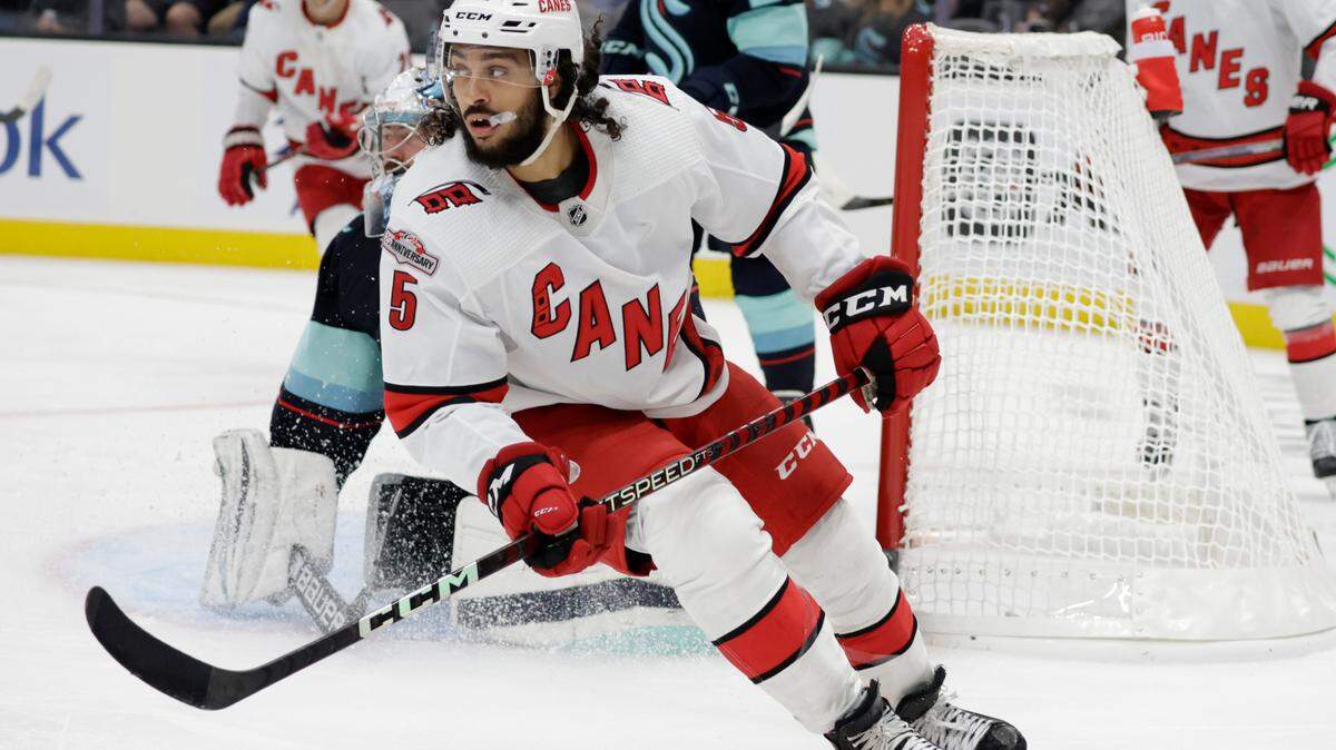 Carolina Hurricanes defenseman Jalen Chatfield (5) looks to the action as he skates away from the goal against the Seattle Kraken during the third period of an NHL hockey game, Monday, Oct. 17, 2022, in Seattle. (AP Photo/John Froschauer)