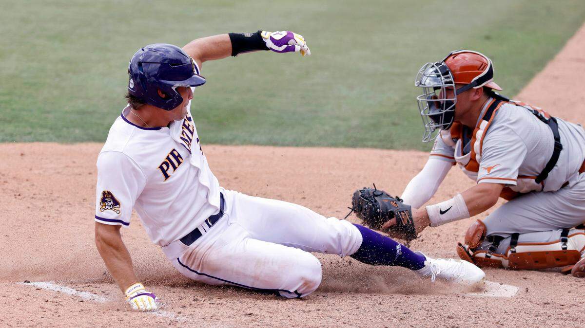 East Carolina’s Bryson Worrell (35) slides in under the tag of Texas’ Silas Ardoin (4) to score in the seventh inning during ECUís 13-7 victory over Texas in the Greenville Super Regional at Clark-LeClair Stadium Friday, June 10, 2022.