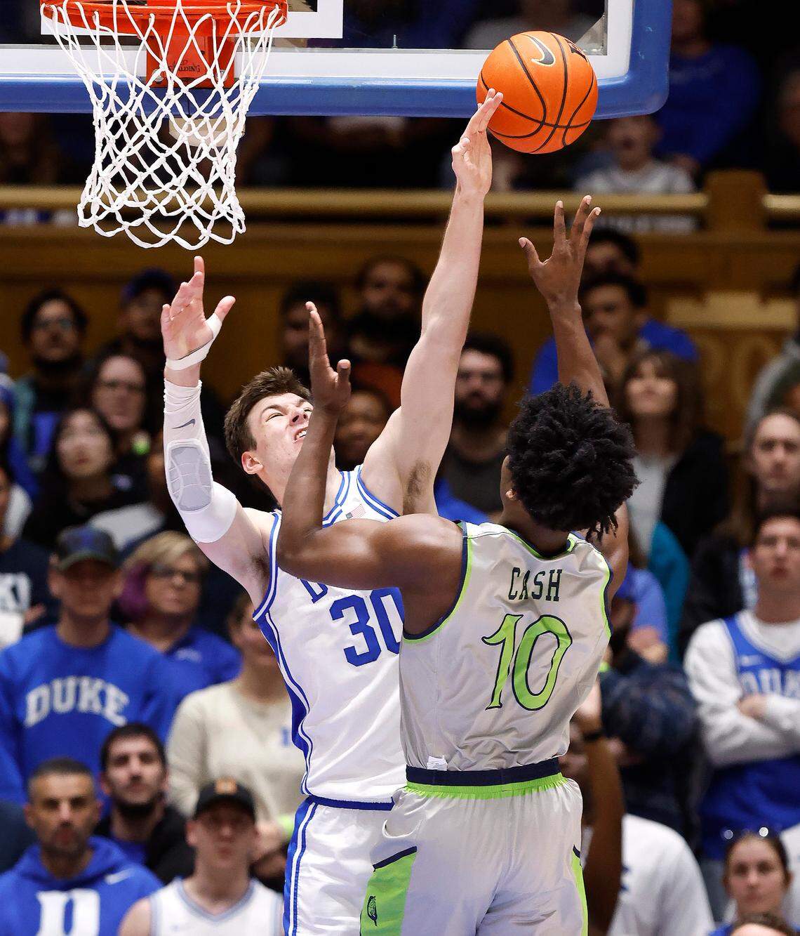 Duke’s Kyle Filipowski (30) blocks the shot by Queens’ Bryce Cash (10) during the first half of Duke’s game against Queens University at Cameron Indoor Stadium in Durham, N.C., Saturday, Dec. 30, 2023.