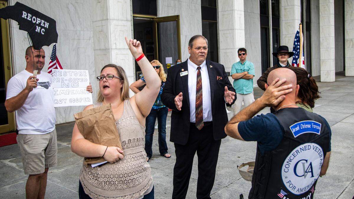 Republican State Rep. Keith Kidwell talks with Reopen NC demonstrators outside the Legislative Building, Wednesday, July 8, 2020. The protesters were demanding the impeachment of Gov. Roy Cooper.